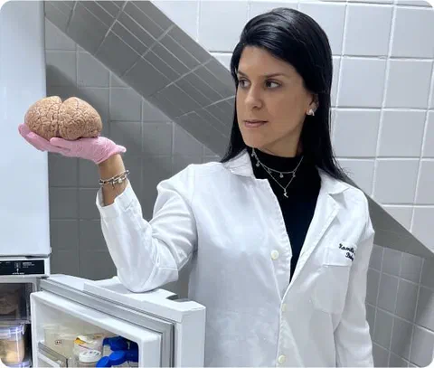 Kamilla Souza sosteniendo un cerebro de delfín en el laboratorio